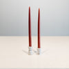 Small and large candleholders with tapered candles, side by side, difference of one inchin size.