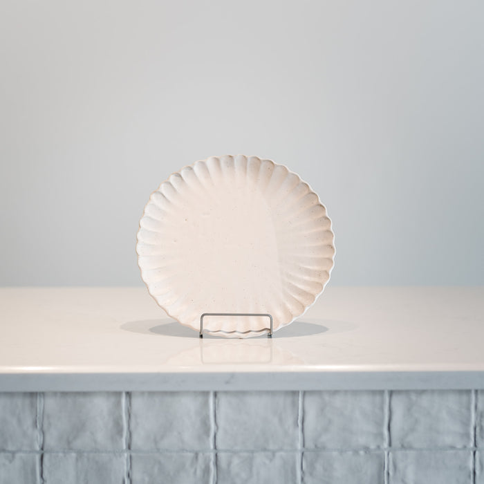 The plate is finished in a matte blush glaze and has a soft, speckle to its surface.